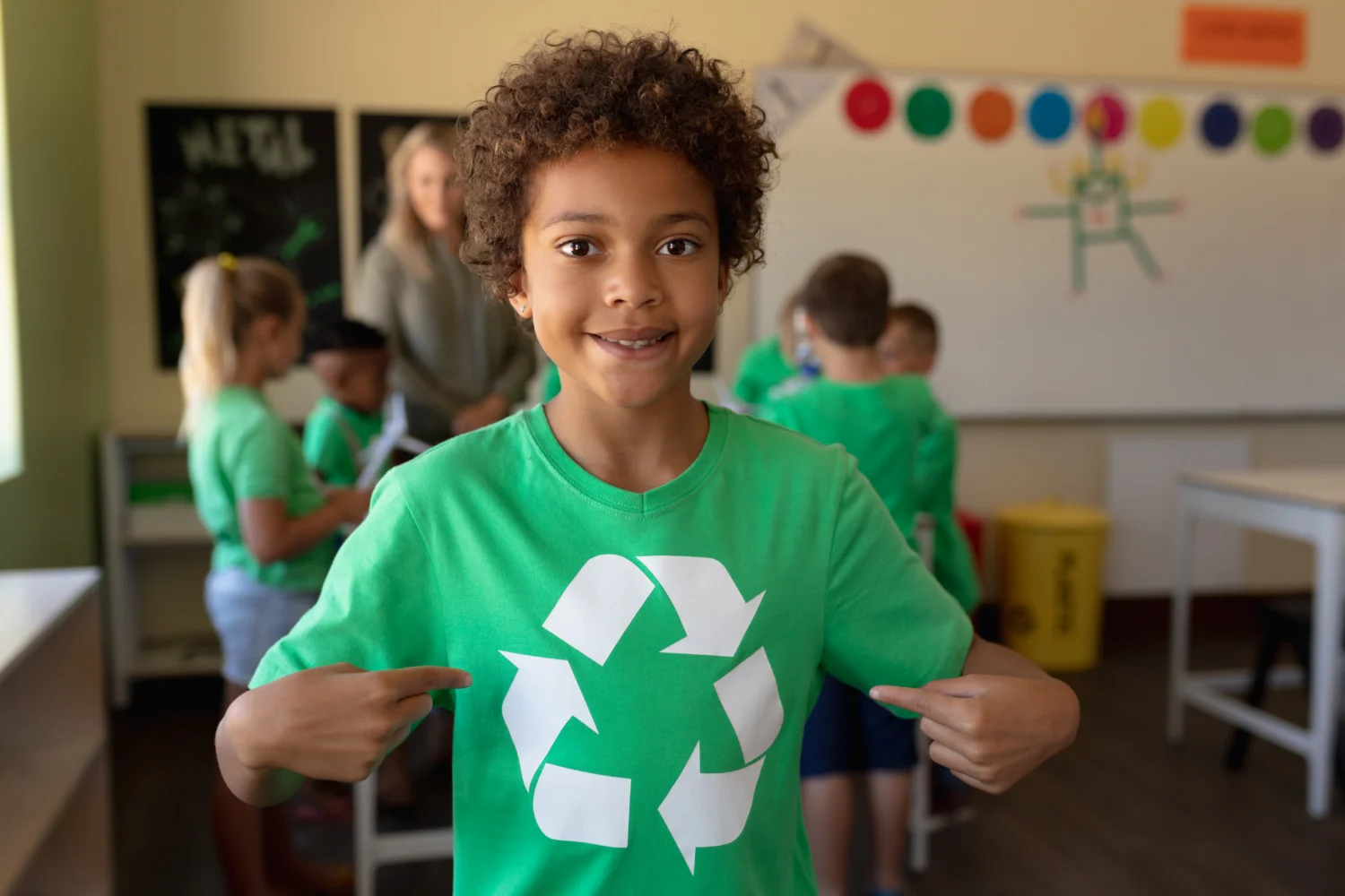 Schoolboy wearing green t shirt with white recycling logo it